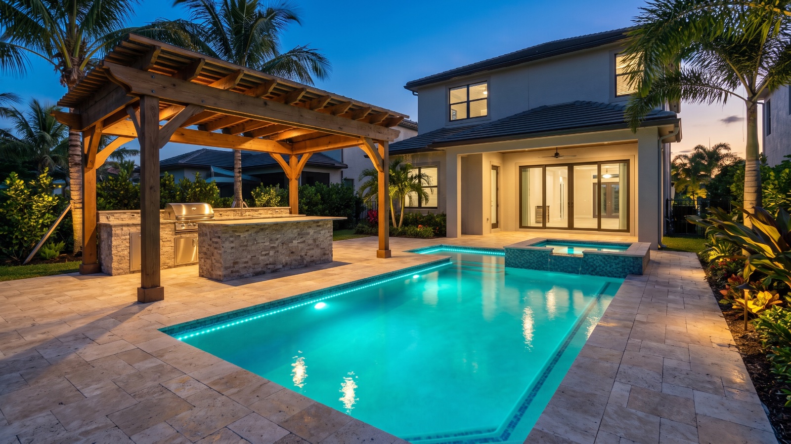 Custom pool with raised spillover spa at dusk